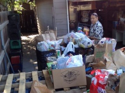 A volunteer inspects goods delivered to Lemoore Christian Aid by Lemoore postal service letter carriers.